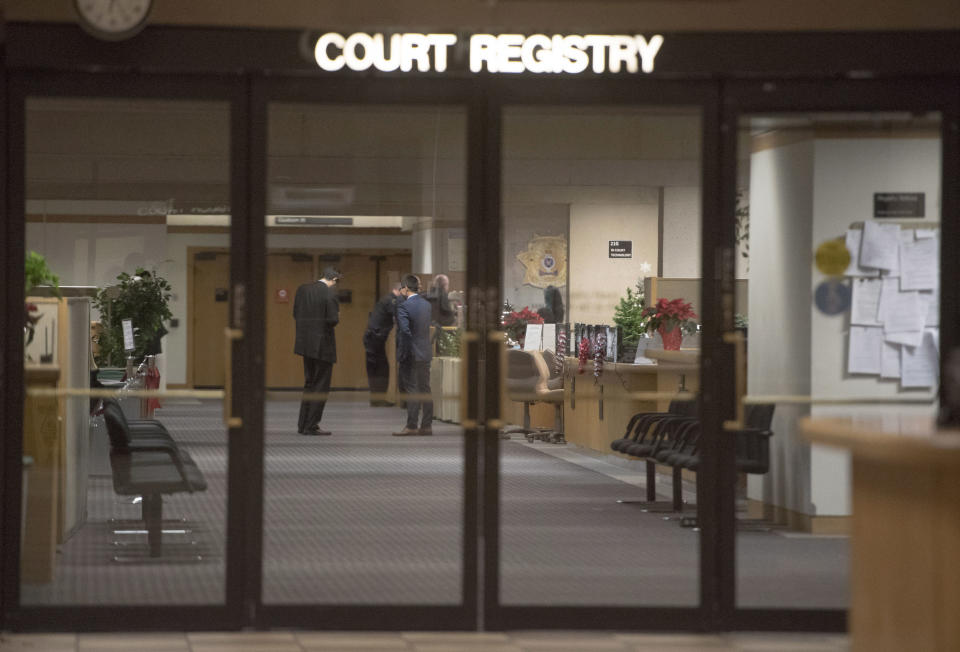 People fill out paperwork at the front desk of a B.C. courthouse after Meng Wanzhou, Huawei's chief financial officer, was granted bail in Vancouver, British Columbia, on Tuesday, Dec. 11, 2018. Wanzhou is wanted by the United States on allegations that the company violated trade sanctions against Iran. (Jonathan Hayward/The Canadian Press via AP)