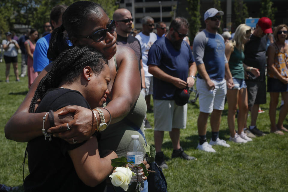 FILE - In this Aug. 4, 2019, file photo, mourners gather at a vigil following a nearby mass shooting in Dayton, Ohio. In the days and weeks since three high-profile shootings took the lives of more than two dozen people in just a week's time, law enforcement authorities have reported seeing a spike in the number of tips they are receiving from concerned relatives, friends and co-workers of people who appear bent on carrying out the next mass shooting. (AP Photo/John Minchillo, FIle)