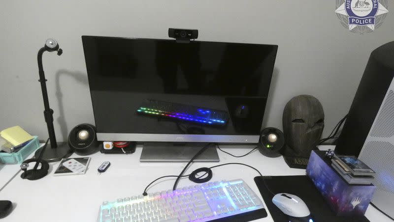 In this undated photo provided by the Australian Federal Police, a suspect’s computer is displayed on a desk. Police have charged 19 men in Australia with child sex abuse offenses and rescued 13 children from further harm following tips from the U.S. Federal Bureau of Investigation, officials said on Aug. 8, 2023.