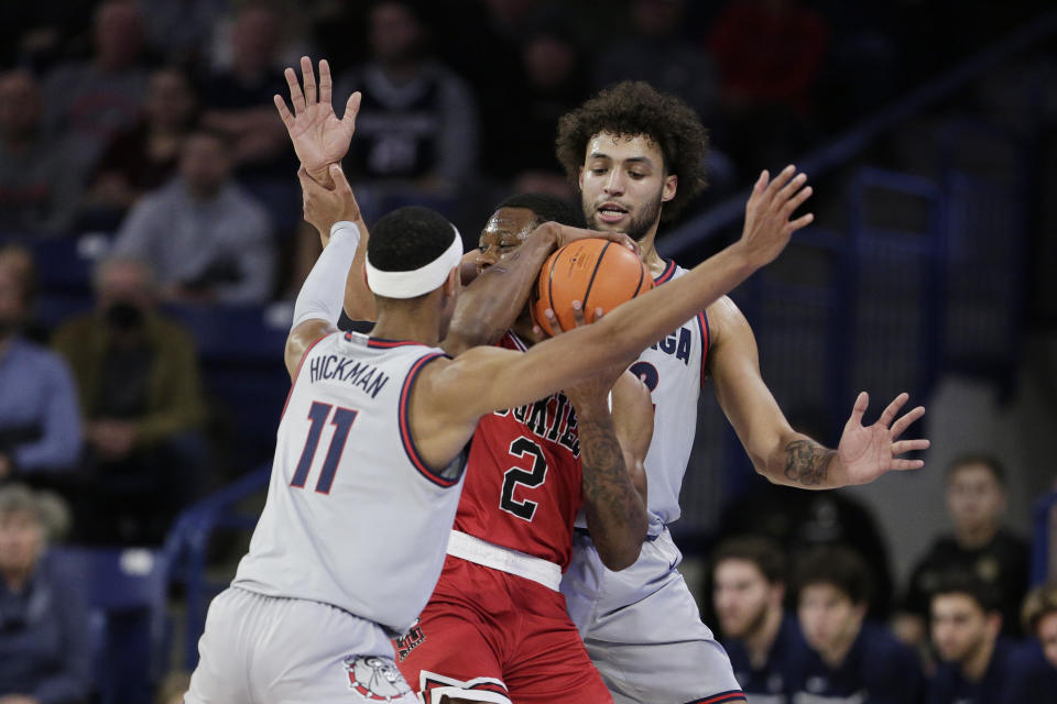 Gonzaga guard Nolan Hickman, left, and forward Anton Watson, right, double-team Northern Illinois guard Zarique Nutter, center, during the first half of an NCAA college basketball game, Monday, Dec. 12, 2022, in Spokane, Wash. (AP Photo/Young Kwak)