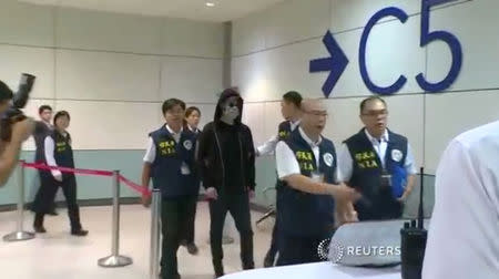 Cody Wilson, a Texan 3-D printed gun maker who flew to Taiwan as police investigated an accusation he had sex with an underage girl, is escorted by immigration officers at Taoyuan international airport, Taiwan, September 22, 2018 in this still image from video. FTV/via Reuters TV.