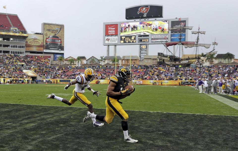Iowa wide receiver Kevonte Martin-Manley (11) pulls in a 4-yard touchdown pass in front of LSU defensive back Rashard Robinson (21) during the fourth quarter of the Outback Bowl NCAA college football game Wednesday, Jan. 1, 2014, in Tampa, Fla. LSU won the game 21-14. (AP Photo/Chris O'Meara)