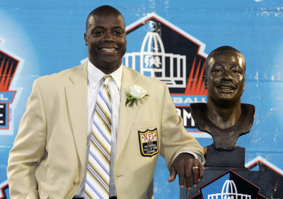 FILE - Former Washington Redskins cornerback Darrell Green stands next to his bronze bust at the Pro Football Hall of Fame in Canton, Ohio, Aug. 2, 2008. The Washington Commanders are retiring Hall of Fame cornerback Darrell Green’s No. 28 next season, the latest step in the organization's efforts to honor players of the past since new ownership took over last summer. The team announced Thursday, April 25, 2024, that Green will be the fifth player in franchise history to receive that honor. (AP Photo/Kiichiro Sato, File)