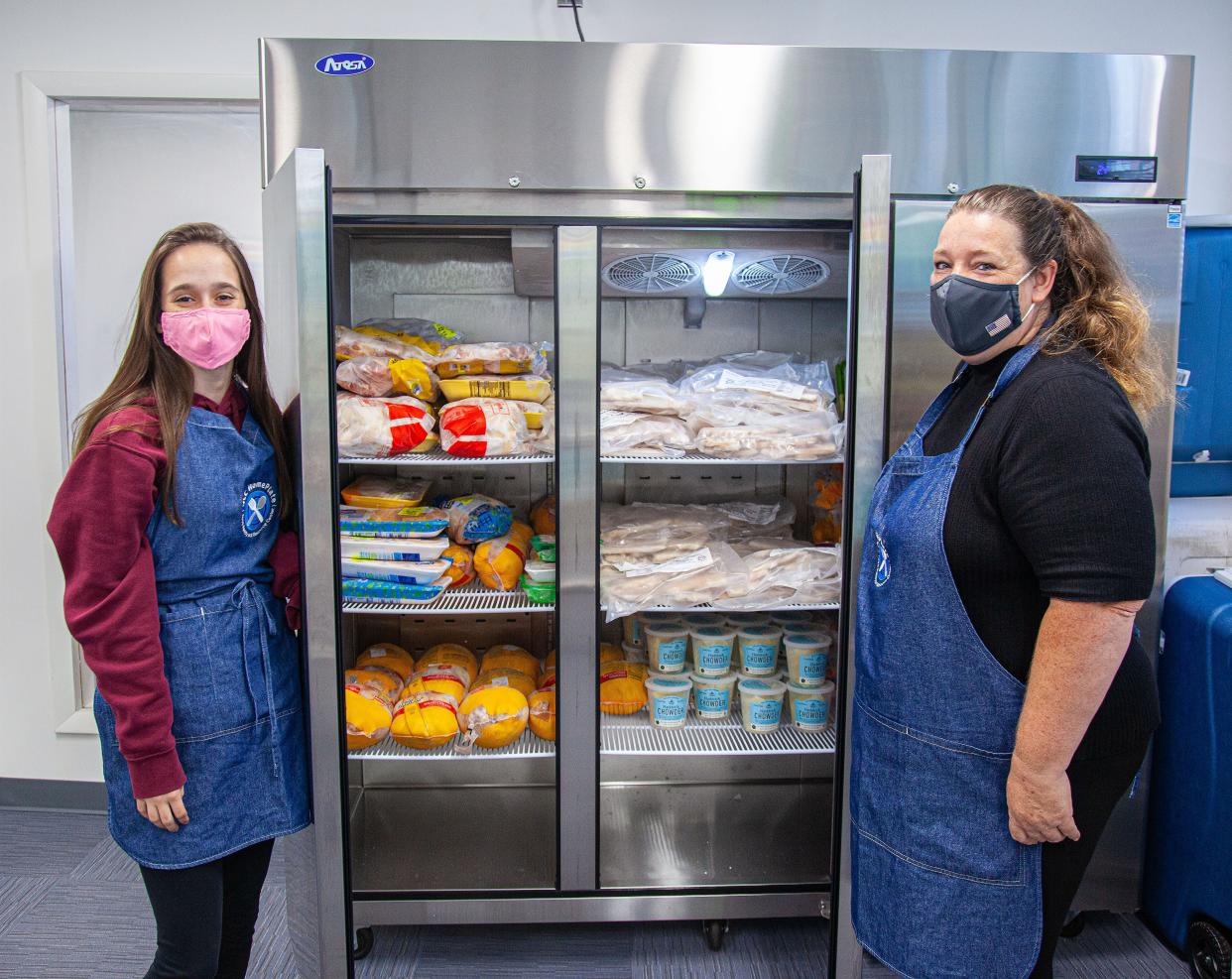 Quinsigamond Community College student Julia Rooney, left, and graduate Cheryl Marrino work in the HomePlate Food Pantry and Resource Center.