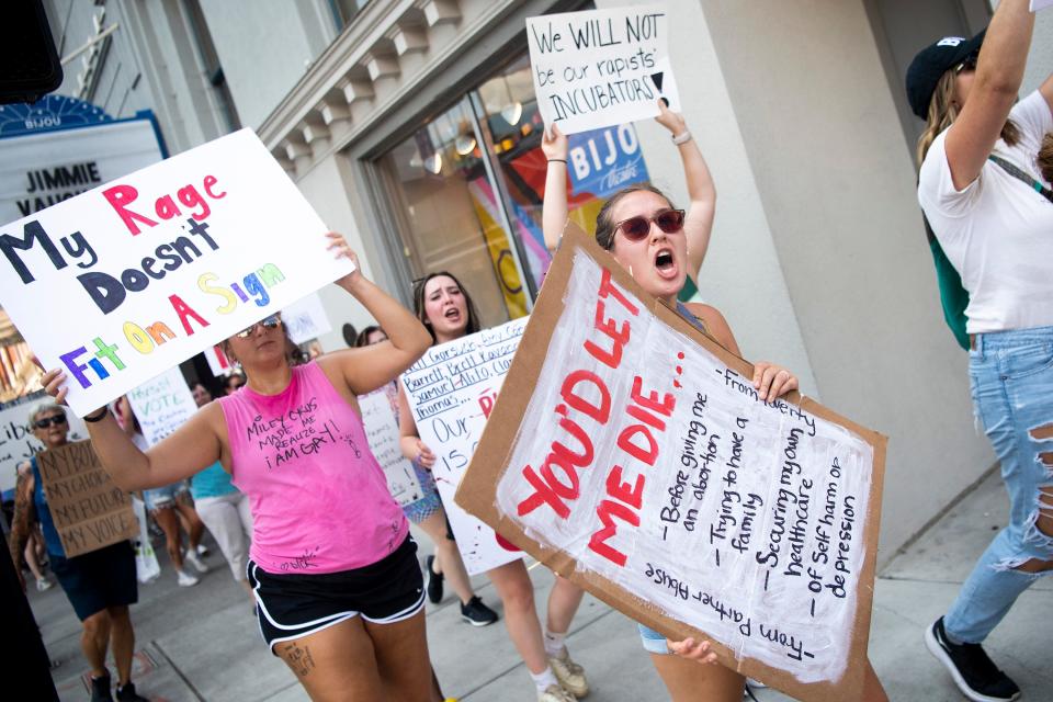 Demonstrators hold signs and chant in support of abortion rights as they march along Gay Street in downtown Knoxville during the Bans Off Our Bodies March on July 5, 2022.