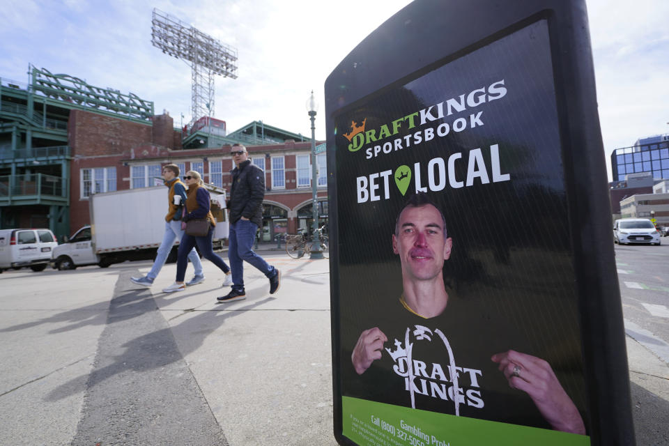 A display on a garbage can features former Boston Bruin Zdeno Chara in a DraftKings advertisement outside Fenway Park, Friday, March 10, 2023, in Boston. Massachusetts sports fans raced to their cell phones Friday, March 10 to begin placing bets as the state allowed online sports wagering just days ahead of tip-off of the NCAA Tournament next week. (AP Photo/Charles Krupa)