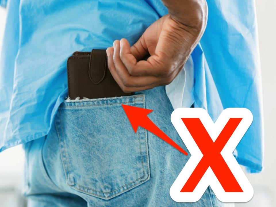 red x and arrow pointing at a man grabbing a wallet out of the back pocket of his jeans