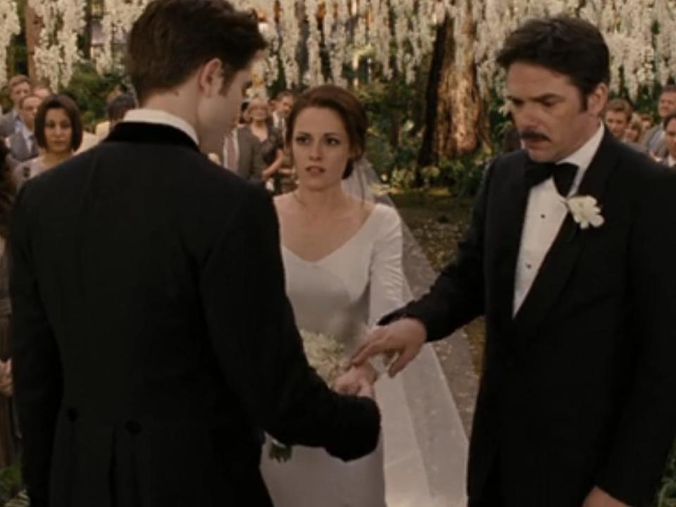 Charlie leading Bella down the aisle in front of Edward during wedding scene in "The Twilight Saga: Breaking Dawn, Part 1"
