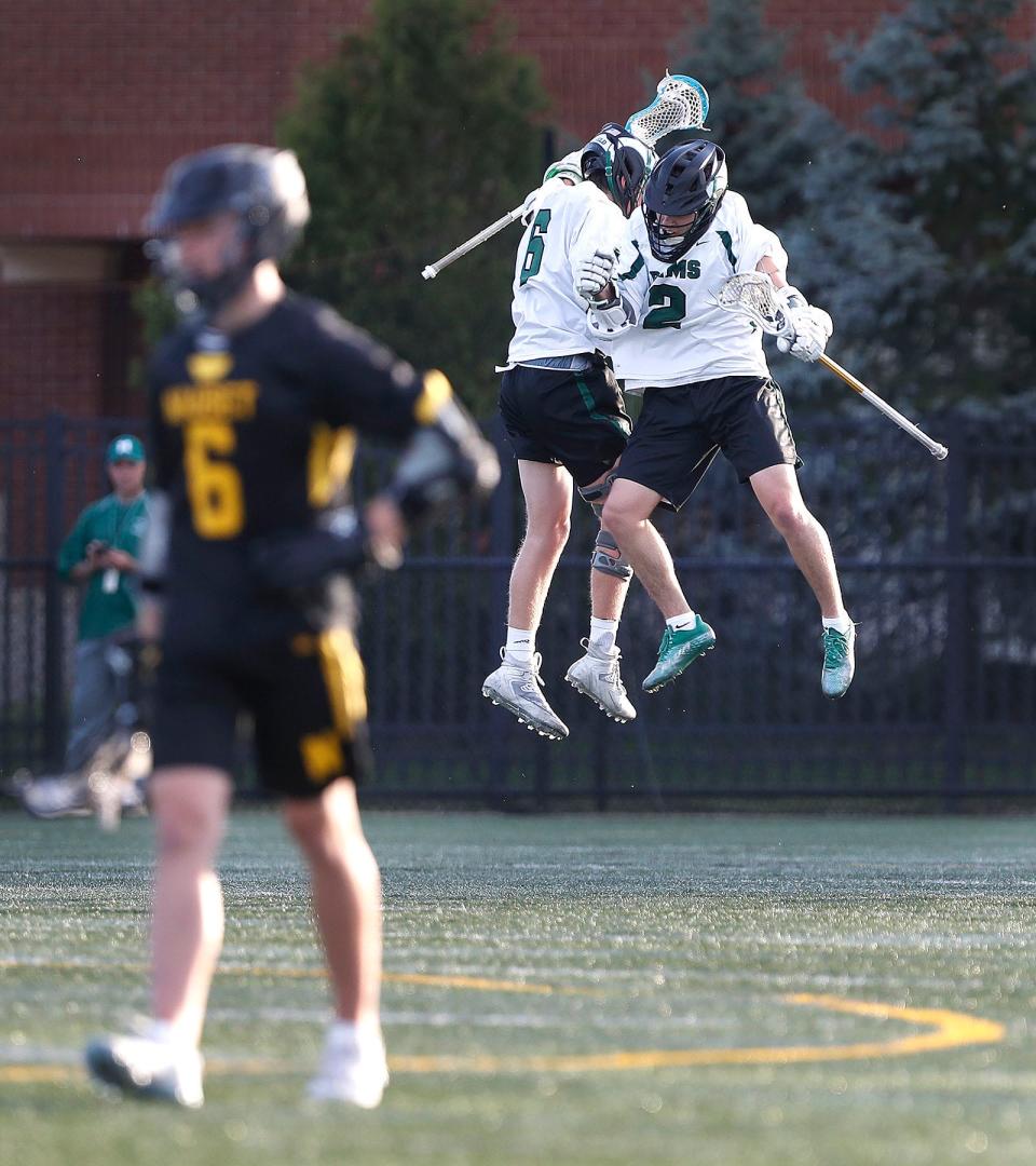 Will Rand, left, and Nic Cupples celebrate Cupples' first-quarter goal. Marshfield hosted Nauset in boys lacrosse in a sunset match on Friday, May 12, 2023.