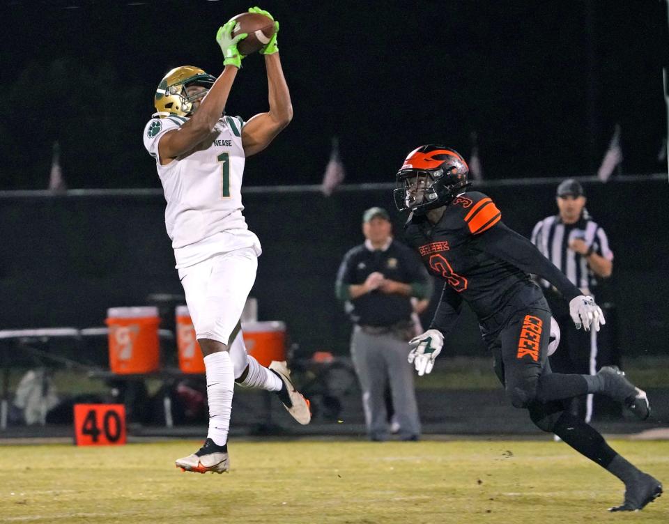 Nease receiver Dom Henry (1) goes up to make the catch during a playoff game against Spruce Creek.