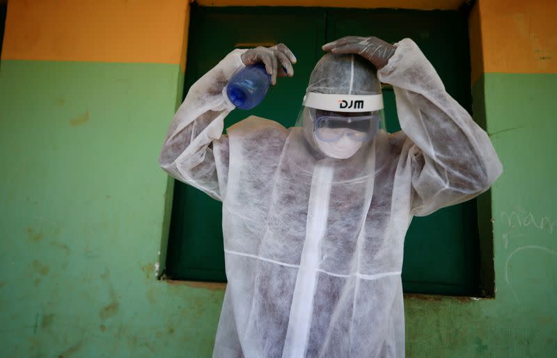 FILE PHOTO: A health worker sprays his headset during a community testing exercise, as authorities race to contain the spread of the coronavirus disease (COVID-19) in Abuja