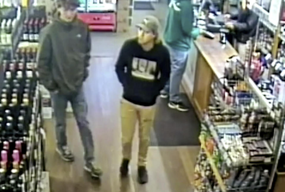 This May 31, 2019, image from CCTV provided Monday, June 17, 2019, by New South Wales Police Force, missing Belgian backpacker Theo Hayez, center, wearing black hooded jumper, inside liquor store in Byron Bay, Australia. Theo's father Laurent Hayez said an encrypted phone message sent by him could hold a clue to the 18-year-old tourist's disappearance from an Australian coastal town. Theo Hayez was last seen leaving a Byron Bay nightclub late on May 31. Police said they are baffled by the disappearance. His father Laurent Hayez flew to Australia last week to take part in the search.(New South Wales Police Force via AP)