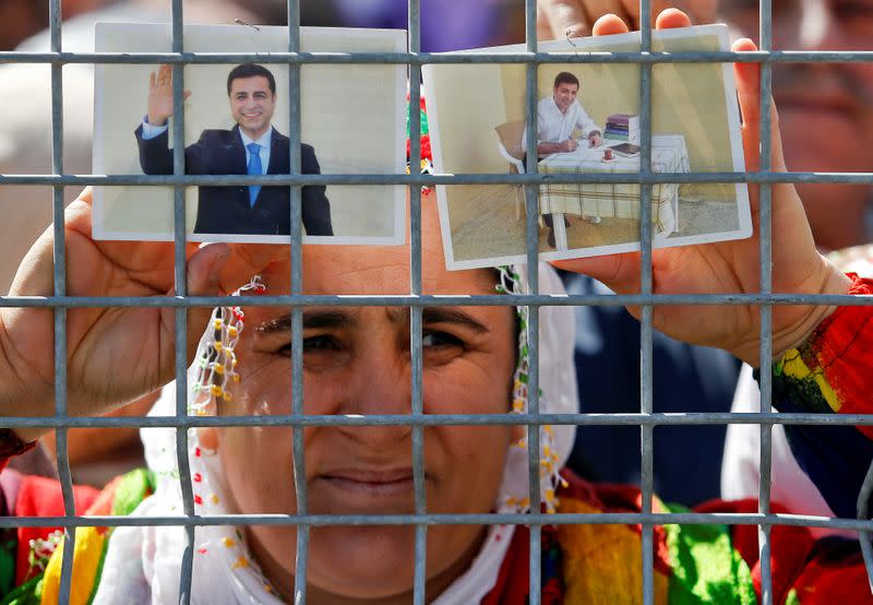 FILE PHOTO: A woman holds pictures of jailed former leader of Turkey's main pro-Kurdish Peoples' Democratic Party Selahattin Demirtas as people gather to celebrate Newroz, which marks the arrival of spring and the new year, in Istanbul