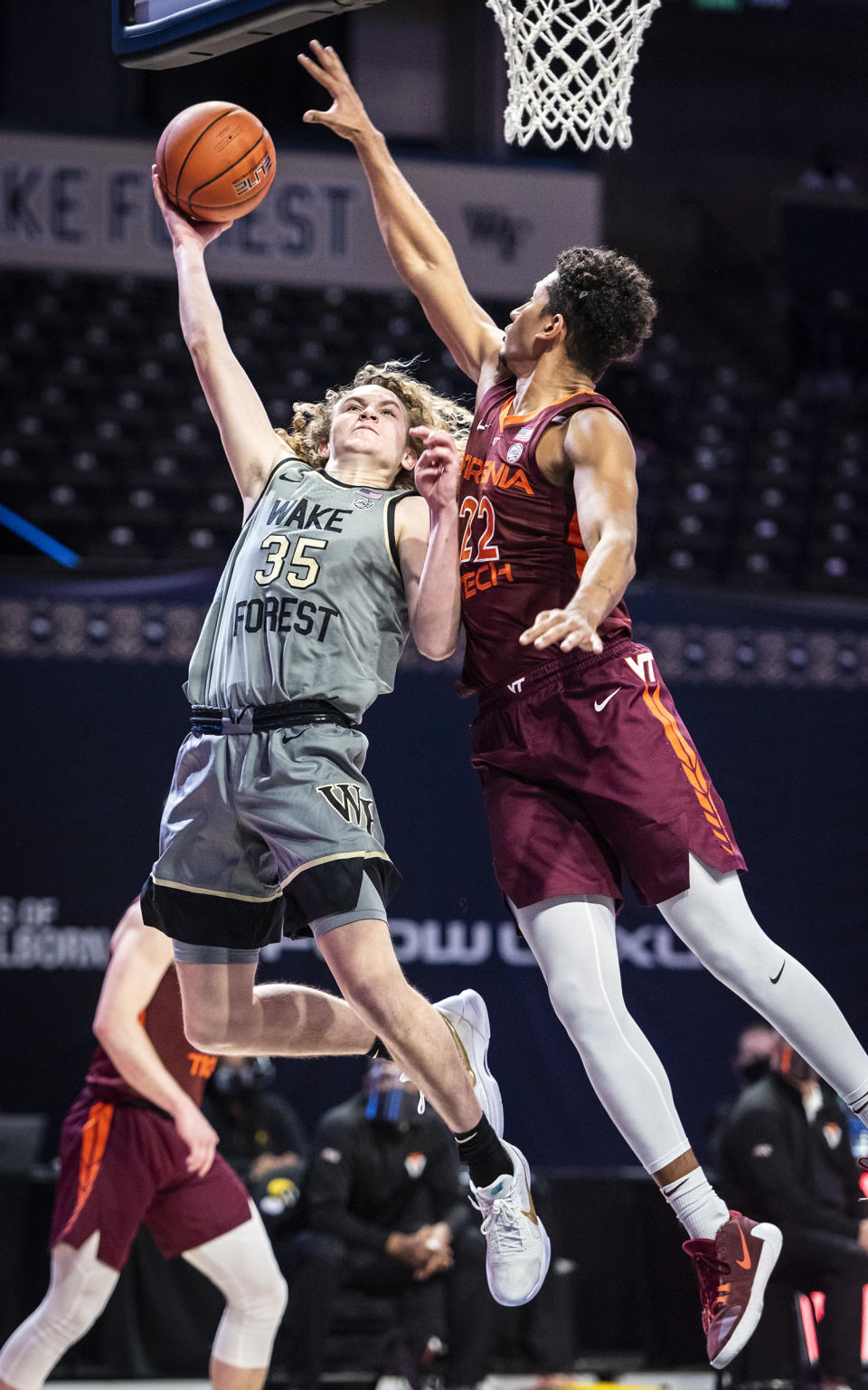 Wake Forest guard Carter Whitt (35) shoots under defense from Virginia Tech forward Keve Aluma (22) during an NCAA college basketball game Sunday, Jan. 17, 2021, in Winston-Salem, N.C. (Andrew Dye/The Winston-Salem Journal via AP)