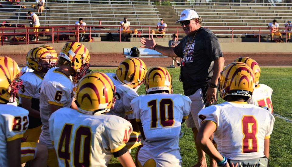 Los Banos High School coach Dustin Caropreso talks to a group of players during practice on Wednesday, Aug. 3, 2022 at Loftin Stadium in Los Banos, Calif.