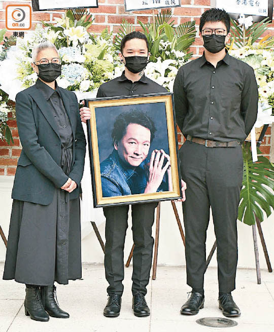 長子文哲捧着亡父遺照步出。