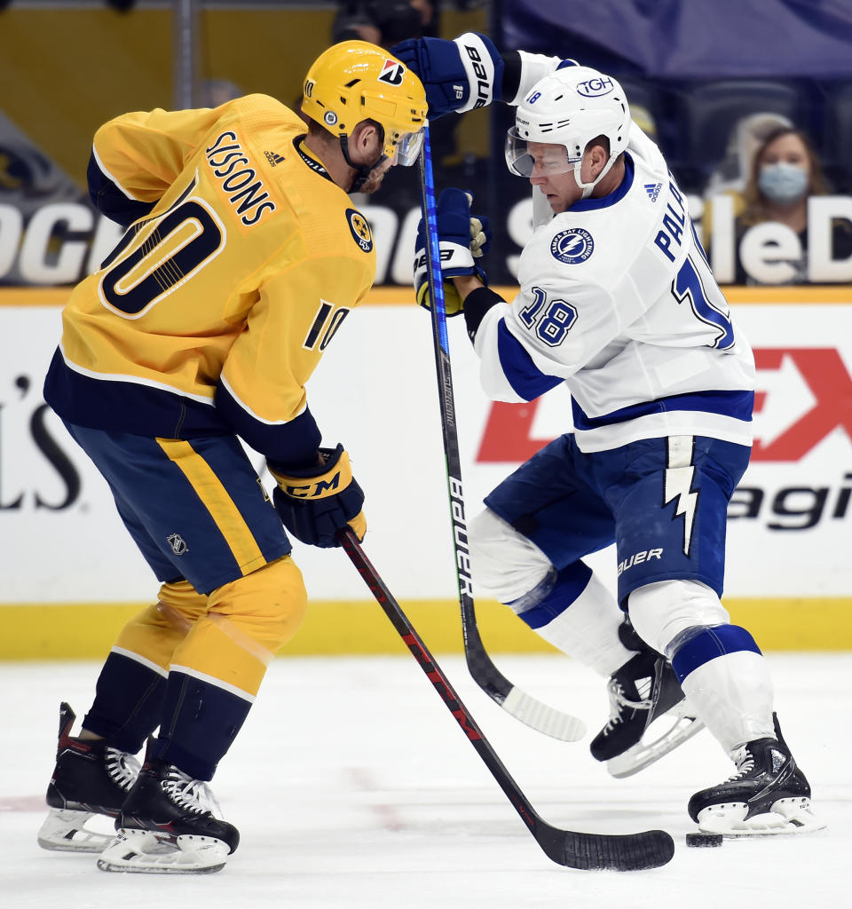 Tampa Bay Lightning left wing Ondrej Palat (18) maneuvers the puck past Nashville Predators center Colton Sissons (10) during the first period of an NHL hockey game Tuesday, April 13, 2021, in Nashville, Tenn. (AP Photo/Mark Zaleski)