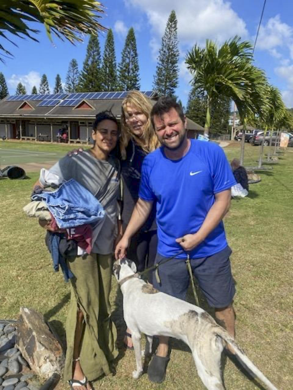This Aug. 9, 2023 photo taken by his stepfather Mike Eilers and provided by Mike Cicchino shows Mike Cicchino holding his dog Raina, right, his wife Andreza Cicchino, left and his mother Susan Ramos pose for a picture as they were reunited at shelter in Maui, Hawaii. (Mike Cicchino via AP)