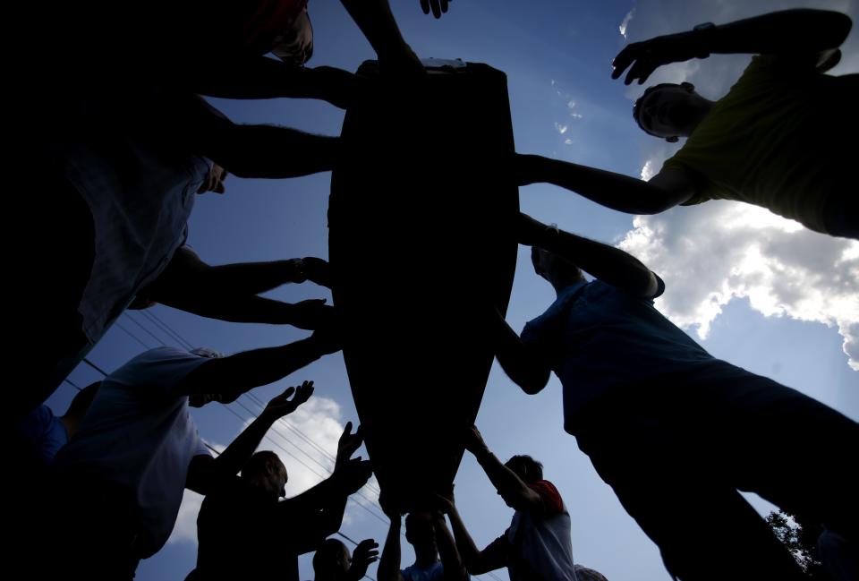 Bosnian Muslims carry coffins with bodies from a mass grave, before a mass funeral in Kozarac, near Prijedor, July 19, 2014. (REUTERS/Dado Ruvic)