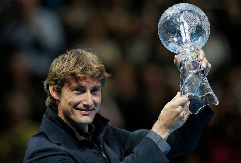 Juan Carlos Ferrero of Spain holds a trophy he received to mark his retirement, during the ATP World Tour Finals in London