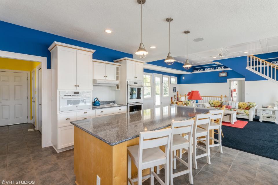 The kitchen offers top-of-the-line appliances and an island for dining.