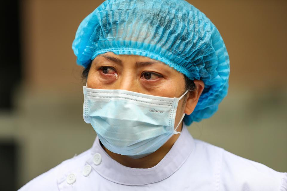 A nurse tears up as she talks about the situation in Jinyintan Hospital, designated for critical COVID-19 patients, in Wuhan in central China's Hubei province Thursday, Feb. 13, 2020. China on Thursday reported 254 new deaths and a spike in virus cases of 15,152, after the hardest-hit province of Hubei applied a new classification system that broadens the scope of diagnoses for the outbreak, which has spread to more than 20 countries. (Chinatopix Via AP)