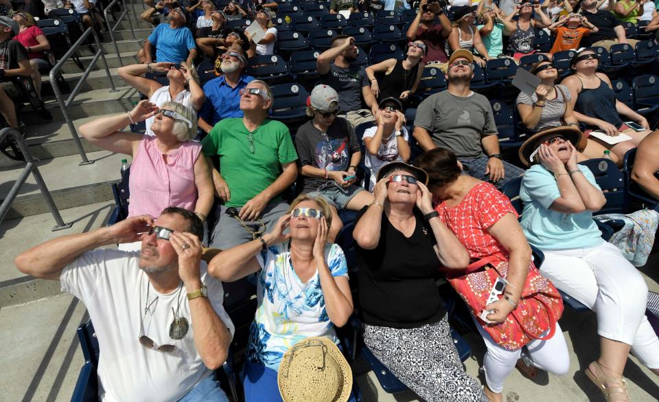 The crowd at the Nashville eclipse-viewing party watches the start of the eclipse at First Tennessee Park.