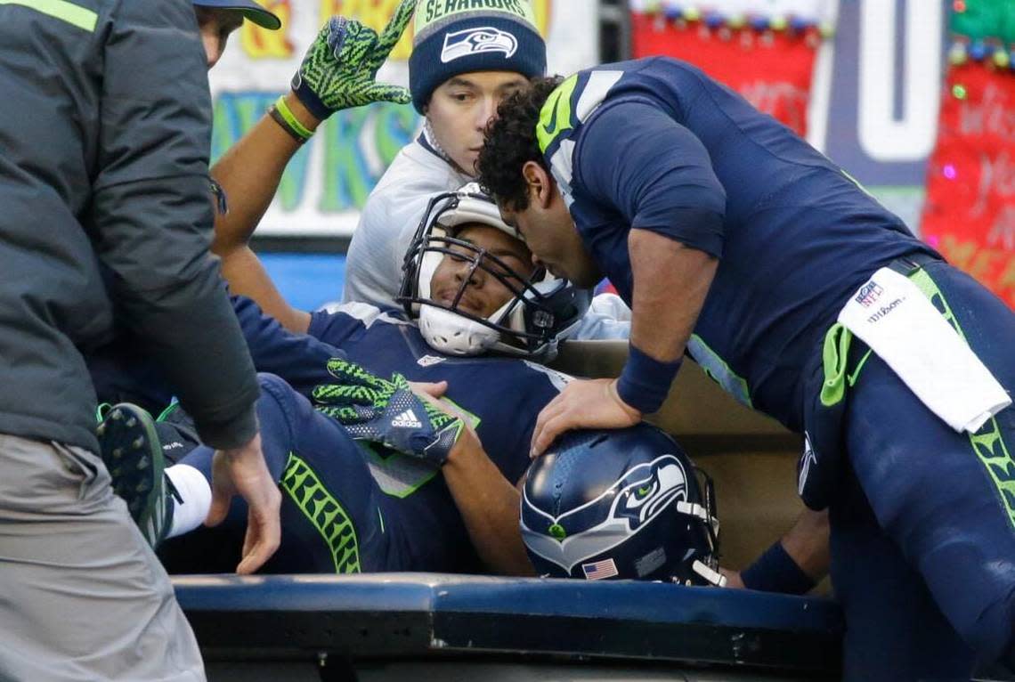 Seahawks receiver Tyler Lockett is embraced by Russell Wilson after being injured against the Arizona Cardinals in the first half on Saturday.