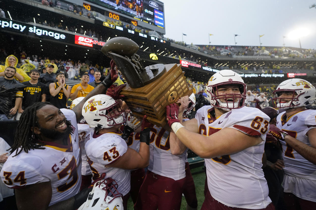 Iowa State players celebrate with the Cy-Hawk Trophy after an NCAA college football game against Iowa, Saturday, Sept. 10, 2022, in Iowa City, Iowa. Iowa State won 10-7. (AP Photo/Charlie Neibergall)