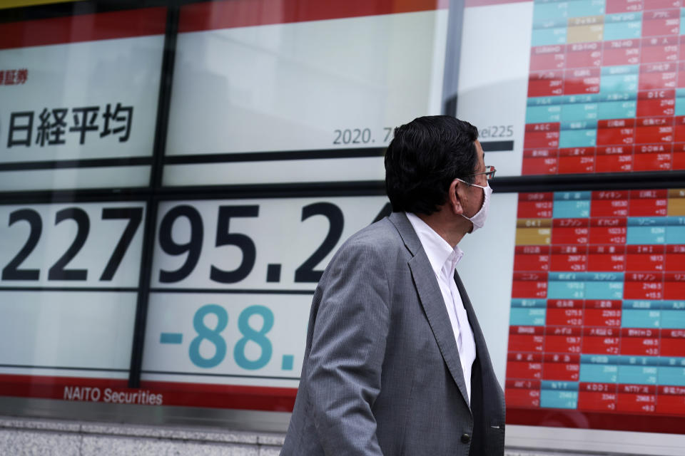 A man wearing a face mask looks at an electronic stock board showing Japan's Nikkei 225 index at a securities firm in Tokyo Wednesday, July 22, 2020. Shares were mixed in Asia on Wednesday, with Australia’s benchmark down more than 1% on reports of a sharp rise in coronavirus cases in the Melbourne area. (AP Photo/Eugene Hoshiko)