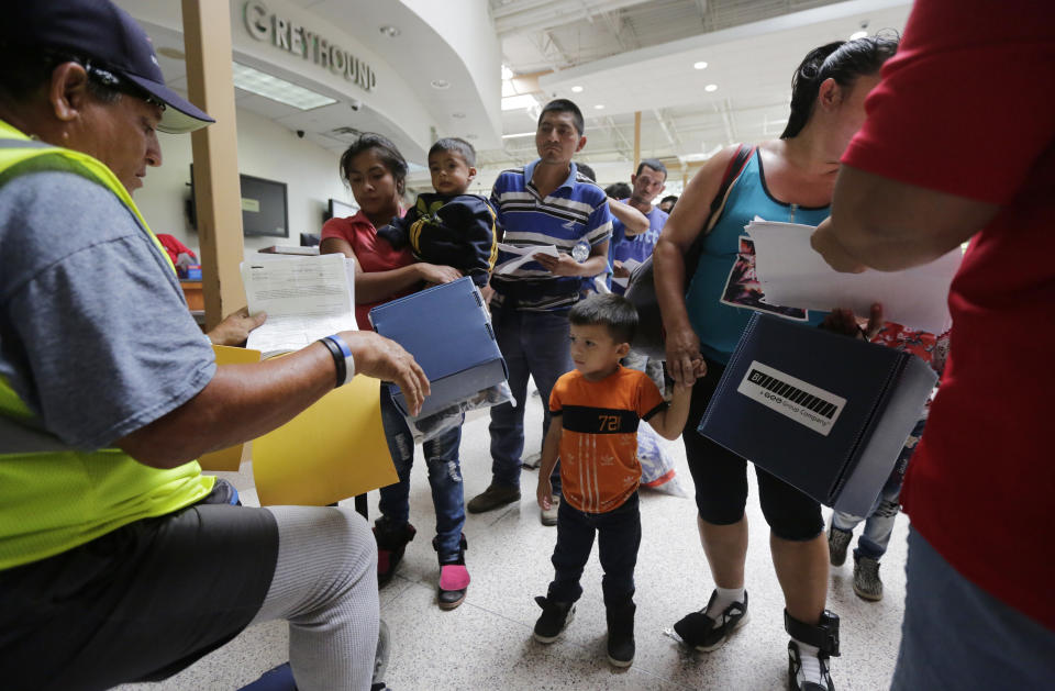 Immigrant families seeking asylum stand in line at the bus station after they were processed and released by U.S. Customs and Border Protection on June 29, 2018, in McAllen. (Photo: Eric Gay/AP)