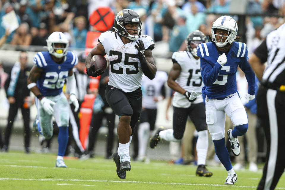 Jacksonville Jaguars running back James Robinson (25) outruns Indianapolis Colts cornerback Stephon Gilmore (5) for a touchdown during the first half of an NFL football game, Sunday, Sept. 18, 2022, in Jacksonville, Fla. (AP Photo/Gary McCullough)