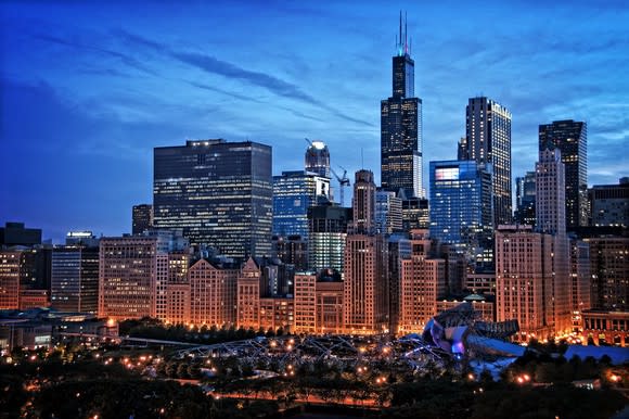 Chicago skyline from Millennium Park, including the Willis Tower and other Loop buildings under a twilight sky with cirrus clouds.