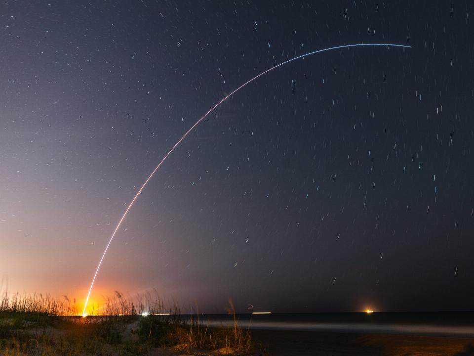 A picture shows the arc drawn by the rocket's exhaust fumes on the night sky.