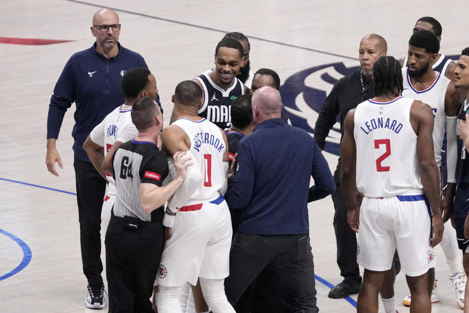 Referee Justin Van Duyne (64) holds Los Angeles Clippers' Russell Westbrook (0) back and another holds Dallas Mavericks' P.J. Washington after an altercation during the second half of Game 2 of an NBA basketball first-round playoff series in Dallas, Friday, April 26, 2024. Both players received technical fouls and were ejected from the game. (AP Photo/Tony Gutierrez)