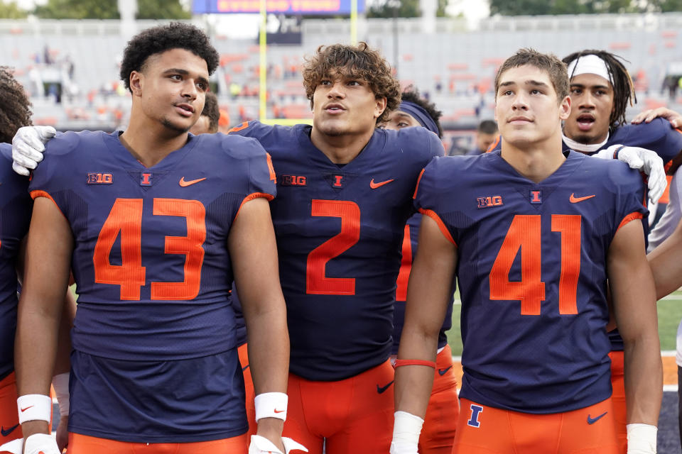 Illinois defensive back Matthew Bailey (2) sings the school's alma mater with teammates Griffin Moore (43) and James Kreutz after an NCAA college football game against Virginia Saturday, Sept. 10, 2022, in Champaign, Ill. Illinois won 24-3. (AP Photo/Charles Rex Arbogast)