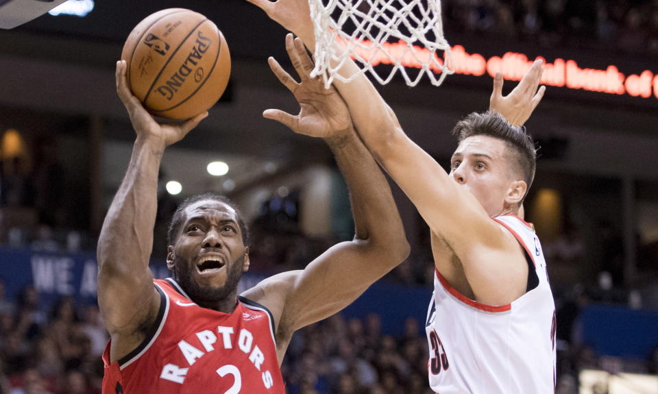 Toronto Raptors forward Kawhi Leonard (2) fights for control of the ball with Portland Trail Blazers forward Zach Collins (33) during the second half of a preseason NBA basketball game, Saturday, Sept. 29, 2018 in Vancouver, British Columbia. (Jonathan Hayward/The Canadian Press via AP)