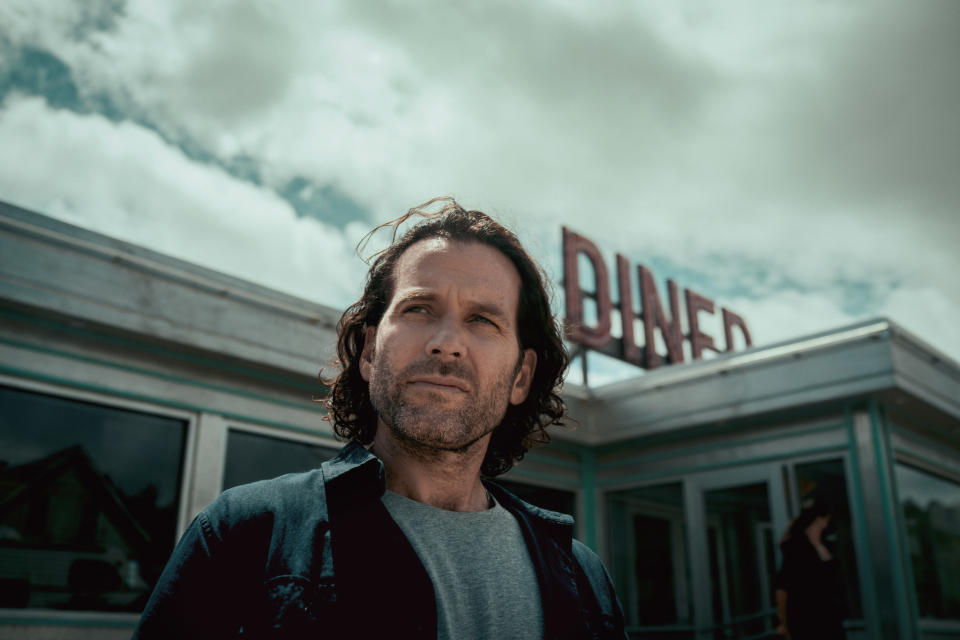 Eion Bailey stands near a diner on a cloudy day