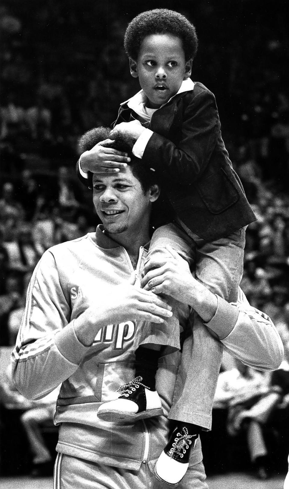 The late Bingo Smith carries his son Andre before a basketball game against the Cleveland Cavaliers on Dec. 4, 1979.