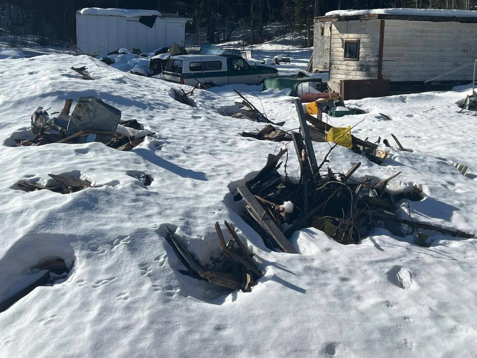 The property remains piled with garbage, oil drums, disused vehicles and a collapsed building, after numerous fines and a clean-up order. Neighbours say in the summer, oil leaks out of the waste.  (Katie Todd/CBC - image credit)