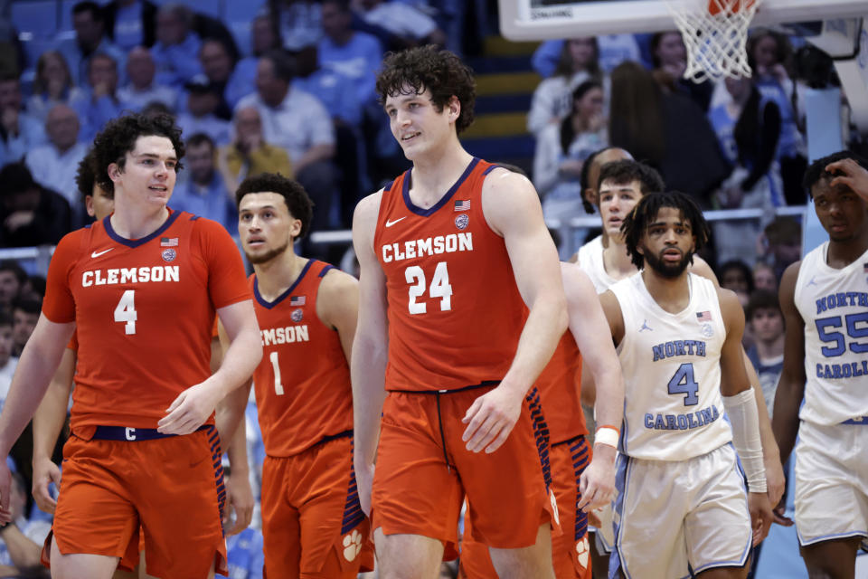 Clemson forward Ian Schieffelin (4) and center PJ Hall (24) smile as North Carolina guard RJ Davis, second from right, and forward Harrison Ingram (55) watch late in the second half of of an NCAA college basketball game Tuesday, Feb. 6, 2024, in Chapel Hill, N.C. (AP Photo/Chris Seward)