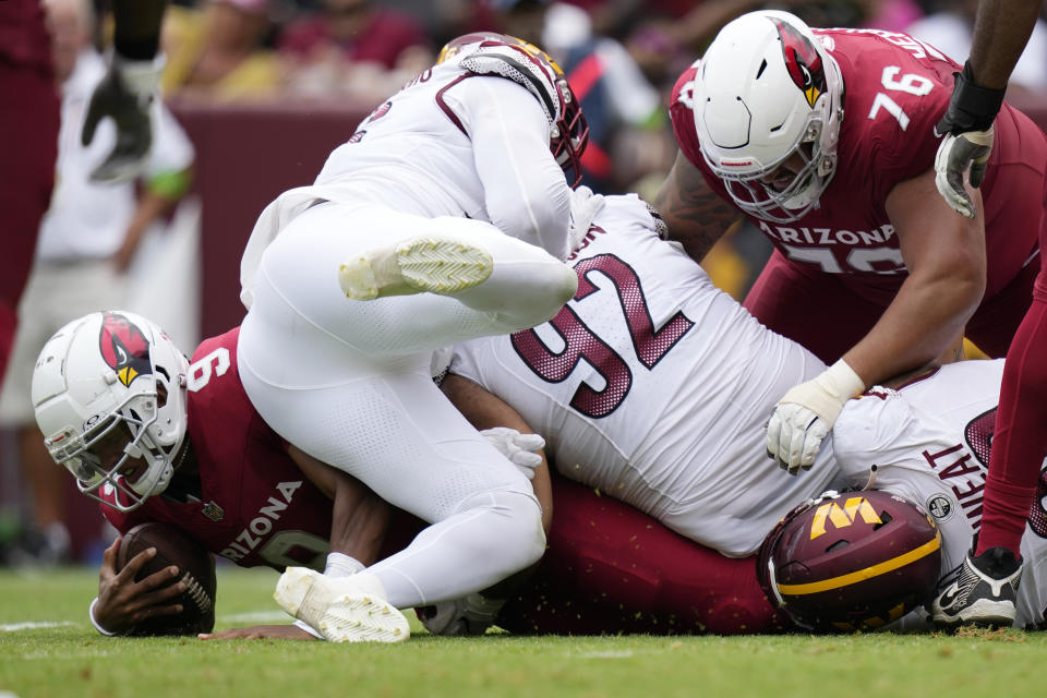 Arizona Cardinals quarterback Joshua Dobbs (9) is sacked during the first half of an NFL preseason football game, Sunday, Sept. 10, 2023, in Landover, Md. Also seen are Washington Commanders defensive tackle Abdullah Anderson (92) and Arizona Cardinals guard Will Hernandez (76). (AP Photo/Alex Brandon)