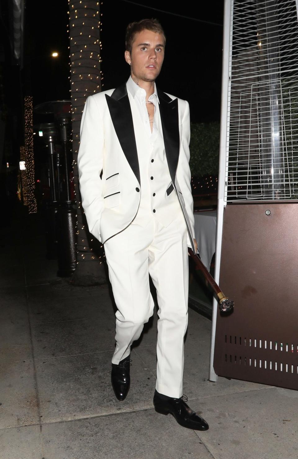 <p>Justin Bieber sports a white suit and carries a cane as he heads to a dinner party with friends at Crustacean Restaurant in Beverly Hills. </p>