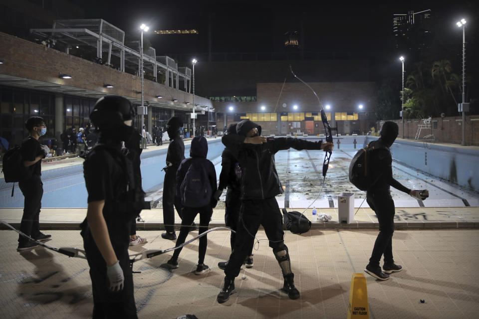 In this Thursday, Nov. 14, 2019, file photo, protesters practice firing bows and arrows at Hong Kong Polytechnic University in Hong Kong. Protesters who barricaded themselves inside Hong Kong’s universities have tried to turn the campuses into armed camps, resorting to medieval weapons to stop police from entering the grounds. Their weapons include bows and arrows, catapults and hundreds of gasoline bombs stacked up to ramparts - often built by the students. (AP Photo/Kin Cheung, File)