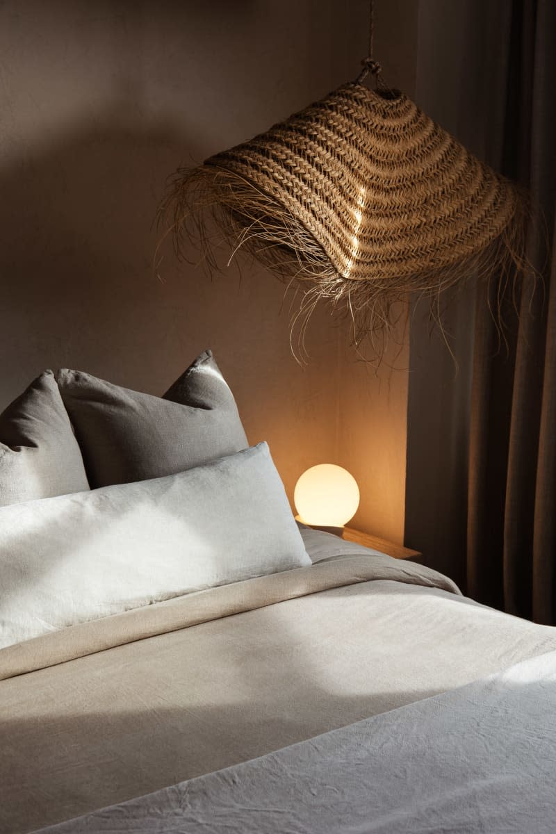 serene beige bedroom with neutral hues and straw/rattan pendant lamp