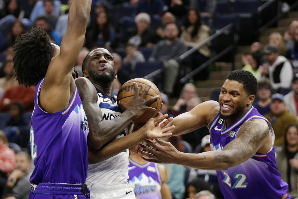 Minnesota Timberwolves forward Taurean Prince, second from left, drives against Utah Jazz forward Rudy Gay (22) and guard Collin Sexton, left, in the third quarter of an NBA basketball game Monday, Jan. 16, 2023, in Minneapolis. (AP Photo/Andy Clayton-King)