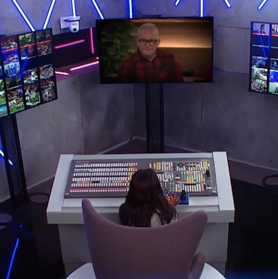 Angela seated at a control panel in front of various TV screens in Big Brother's bunker