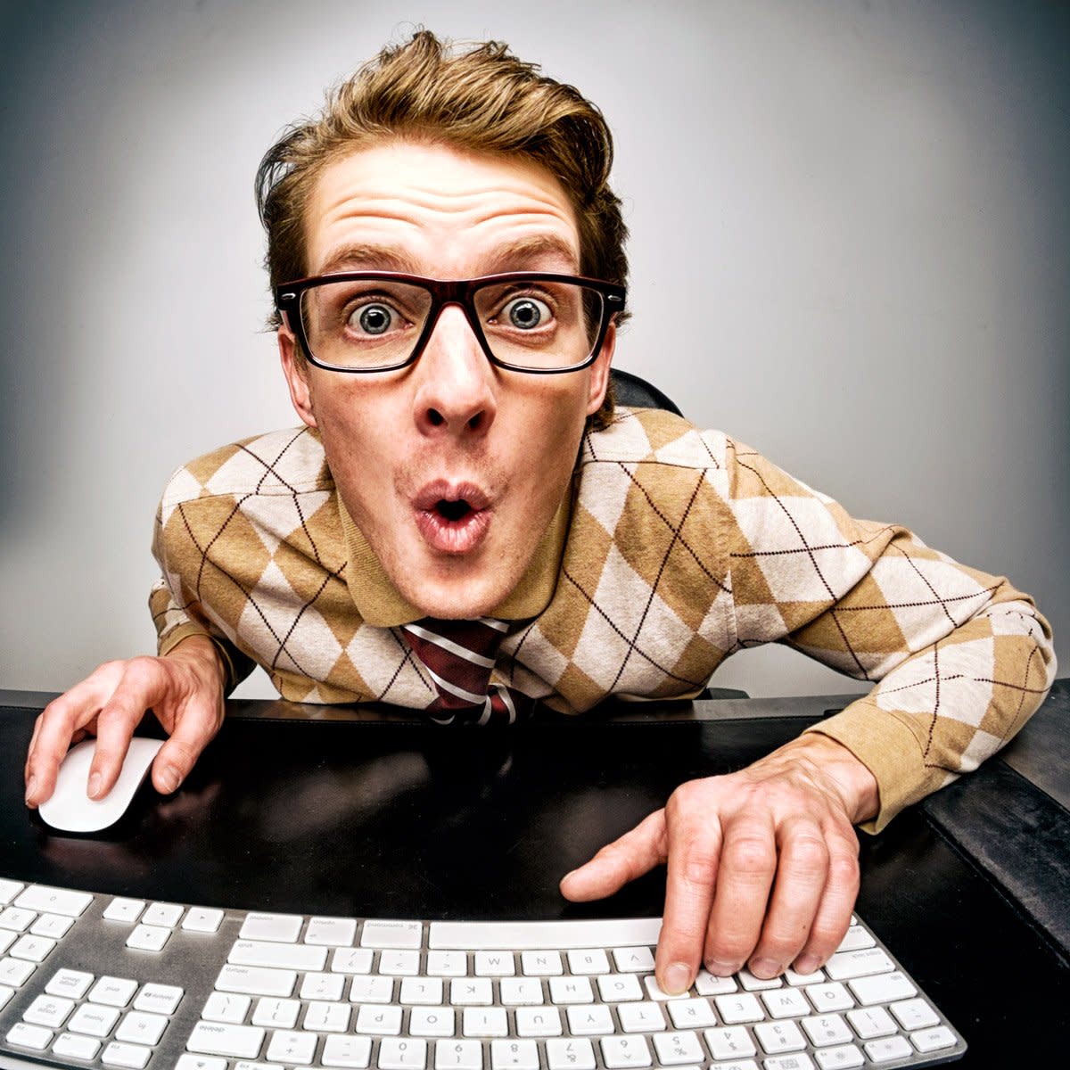 A man looks excited as he types on his keyboard.