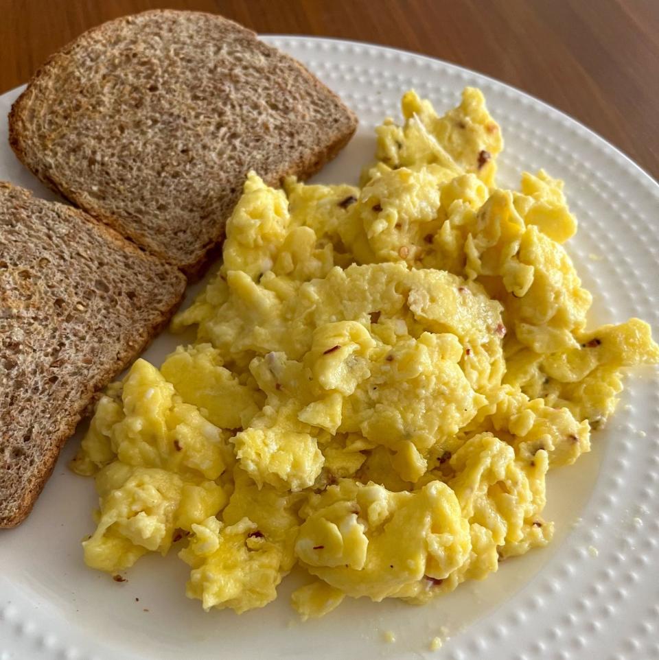 A plate of cottage cheese scrambled eggs and toast.