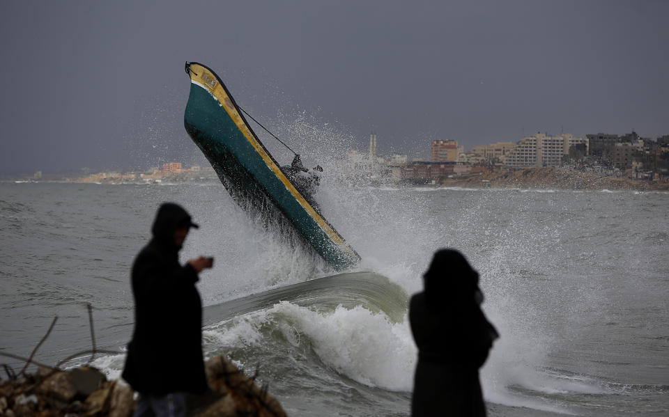 Palestinian fishermen ride their boat amid high waves on windy and rainy day at the sea in Gaza City, Sunday, Feb. 9, 2020. (AP Photo/Hatem Moussa)